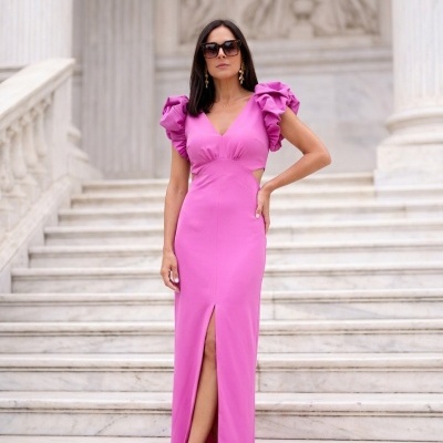 Mulher com vestido comprido rosa em escadaria de mármore