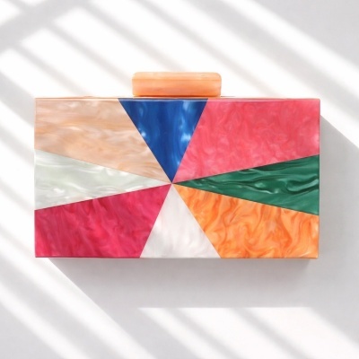 Clutch geométrica colorida com textura marmoreada brilhante.