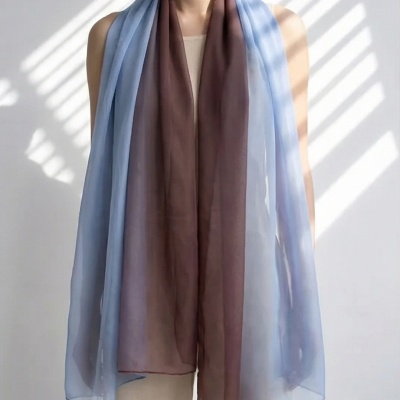 Lenço leve em degradê azul e castanho usado ao pescoço