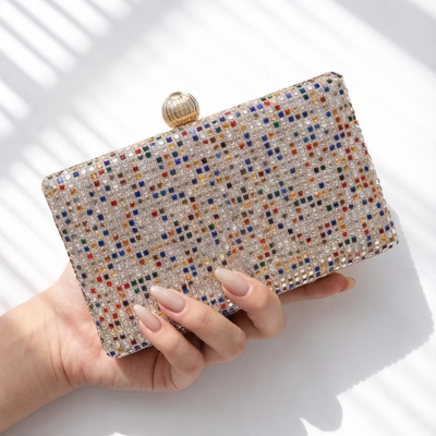 Carteira pequena com aplicações brilhantes multicoloridas segura por mão feminina