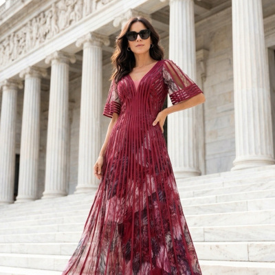 Vestido longo vinho com padrão floral e linhas verticais, usado por mulher em escadaria com colunas brancas