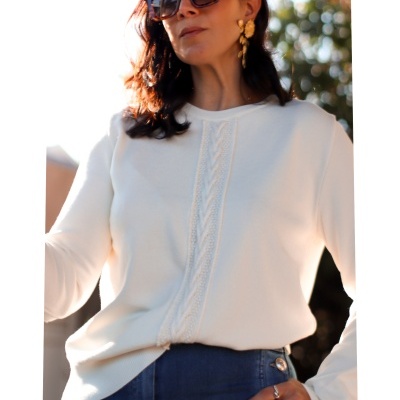 Camisola branca de malha com trança central usada por mulher com calças de ganga