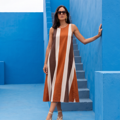 Vestido comprido riscado com tons castanhos e laranja em cenário azul
