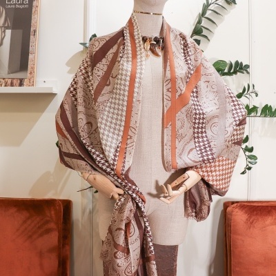 Lenço castanho e bege com padrões variados num manequim com decoração de interior