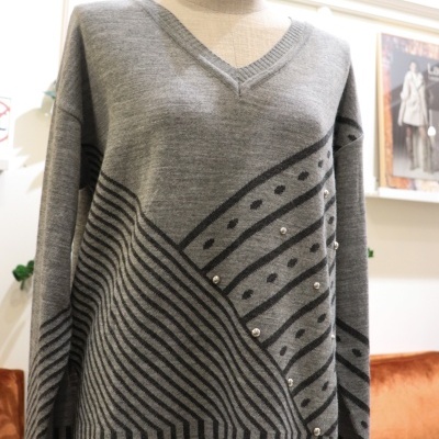 Camisola cinza geométrica com pérolas e decote em V no manequim