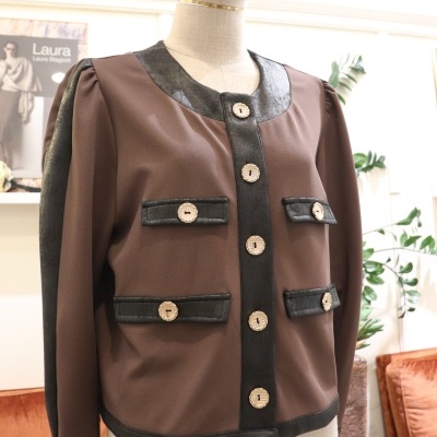 Casaco castanho com detalhes pretos e botões dourados exposto em manequim