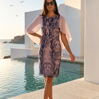 Mulher com vestido flores escuro sobre rosa claro e mangas transparentes ao lado de piscina exterior