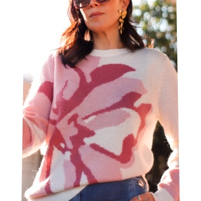 Mulher a usar suéter rosa com padrão floral e óculos escuros pretos