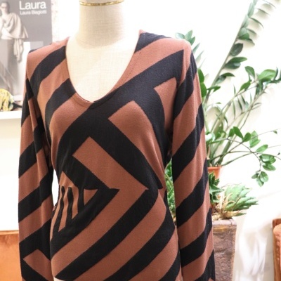 Camisola castanho e preta com padrão geométrico em manequim