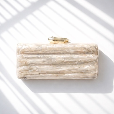 Clutch marmoreada bege com fecho dourado em fundo branco
