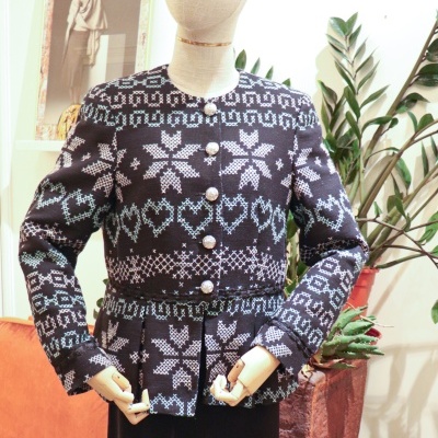 Casaco feminino preto com padrão branco e azul claro em manequim.