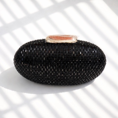 Clutch oval preta decorada com contas e fecho dourado com detalhe pêssego