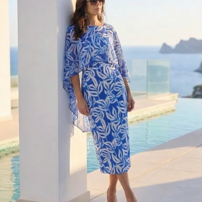 Vestido azul com padrão branco de folhas usado por mulher junto a piscina