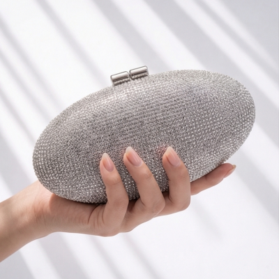 Mala de mão oval prateada com cristais brilhantes e fecho metálico