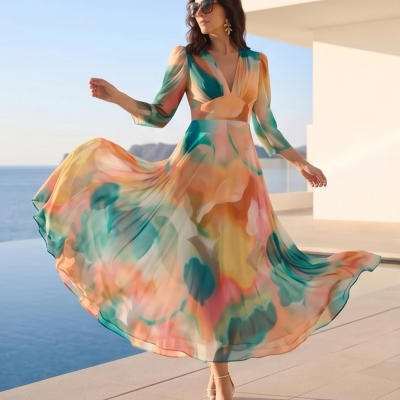 Vestido longo fluido colorido com padrão abstrato e decote em V em ambiente exterior junto ao mar