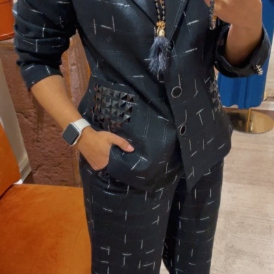 Conjunto de fatos preto com padrão de linhas brancas e detalhes de tachas.