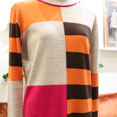 Camisola colorida de malha com padrões geométricos vista numa loja.