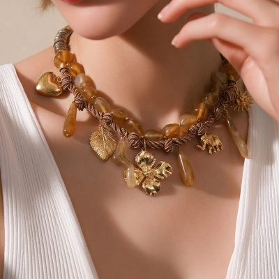 Colar com pedras âmbar e pendentes dourados usado por modelo com top branco