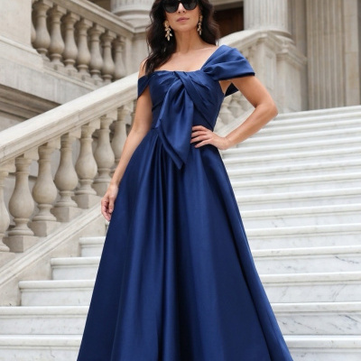Mulher com vestido de noite azul escuro em escadaria de mármore