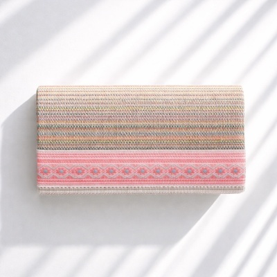 Carteira de tecido colorido com faixa rosa decorativa sobre fundo branco