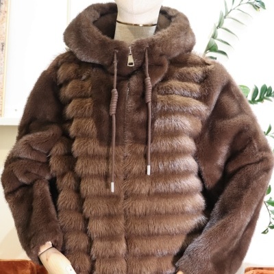 Casaco de pelo sintético castanho com capuz e cordões em manequim