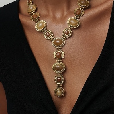 Colar dourado com pedras marrons em vários formatos em pessoa com vestido preto