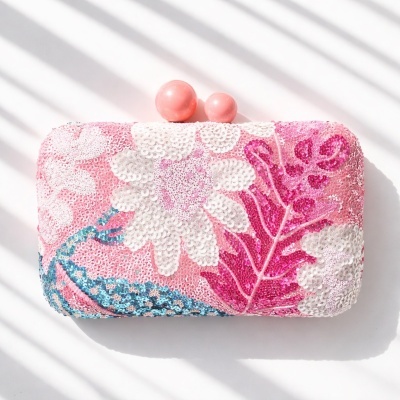 Carteira de mão rosa com padrão floral em lantejoulas e fecho esférico cor de rosa