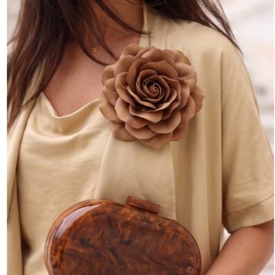 Broche flor castanha tecido em vestido bege claro e clutch marrom marmoreado
