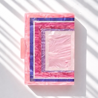 Caixa acrílica corta em padrões geométricos rosa, azul e roxo com efeito marmoreado.