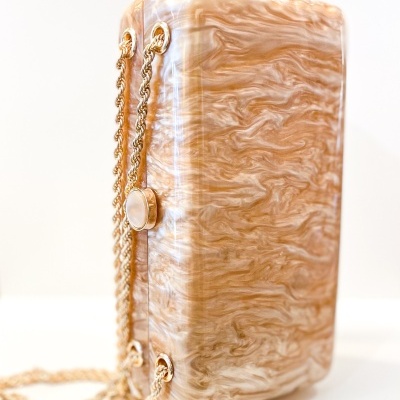 Mala de mão bege marmoreada com correntes douradas