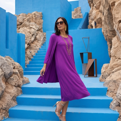 Mulher com vestido roxo, acessórios dourados e sandálias prata em escadaria azul com rochas