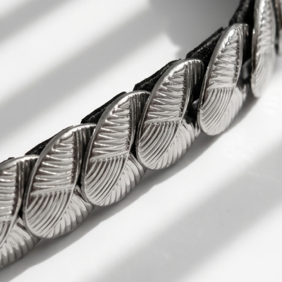 Pulseira de elementos metálicos ovais com textura sobre fundo branco