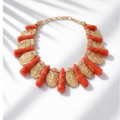 Colar dourado com pendentes ovais texturizados e peças coral brilhantes sobre fundo branco