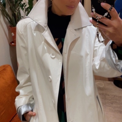 Casaco branco brilhante com gola alta, botões frontais e detalhes prateados nas mangas