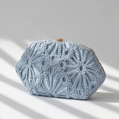 Clutch azul claro com padrão em croché e fecho dourado