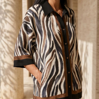 Camisa com padrão animal print em tons castanhos, pretos e brancos com gola preta