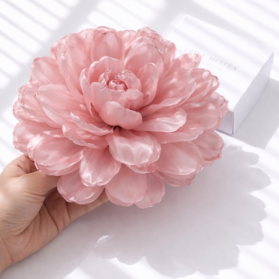 Flor artificial cor-de-rosa com sombra e caixa branca ao fundo