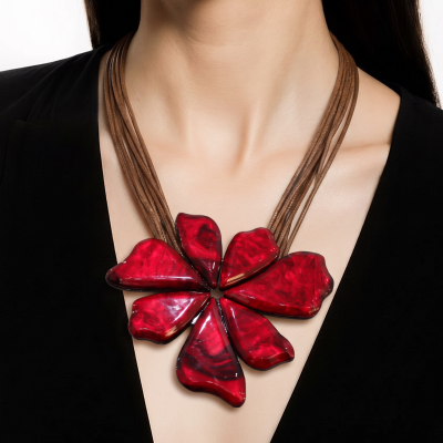 Colar com pendente em forma de flor vermelho e tiras castanho-claras associado a blusa preta