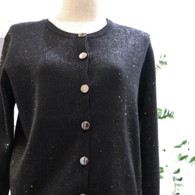 Cardigã preto com botões prateados e padrão de letras B em relevo