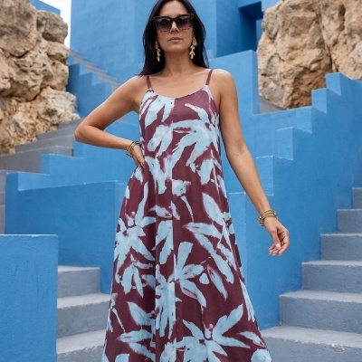 Vestido midi bordô com padrão azul claro e alças finas em escadaria azul.