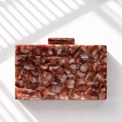 Clutch marmoreada em tons castanhos sobre fundo branco