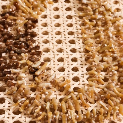 Colar de contas bege castanho sobre superfície de rede de madeira