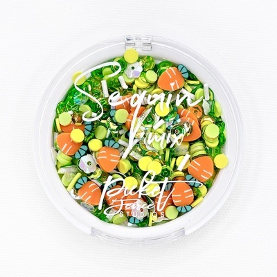 Pote redondo de lantejoulas coloridas com cenouras e texto branco