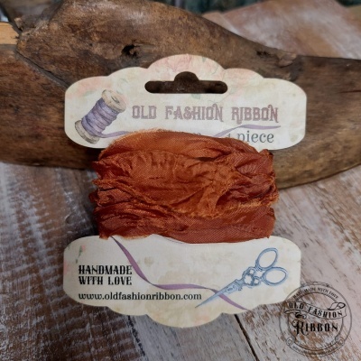 Fita de tecido cor ferrugem com embalagem branca rotulada Old Fashion Ribbon em fundo de madeira