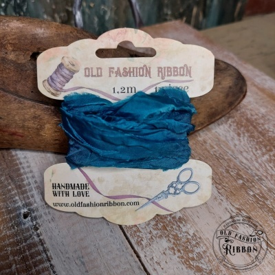 Fita azul escura Old Fashion Ribbon em cartão com ilustrações, sobre mesa de madeira