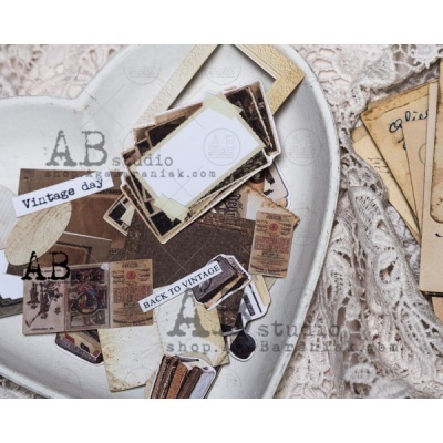 Recortes de papel vintage numa bandeja branca em forma de coração sobre fundo de tecido rendado