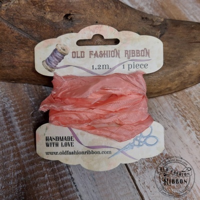Fita de tecido cor de rosa enrolada num cartão com texto OLD FASHION RIBBON