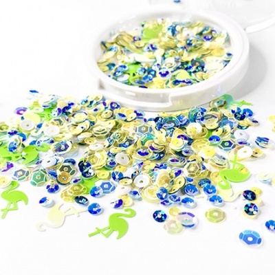 Lantejoulas de várias cores e formas espalhadas em superfície branca