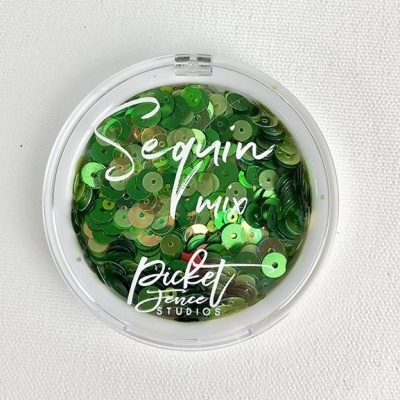 Embalagem redonda com lantejoulas verdes e douradas e texto impresso na tampa