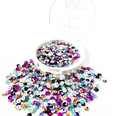 Recipiente transparente com lantejoulas coloridas espalhadas sobre uma superfície branca
